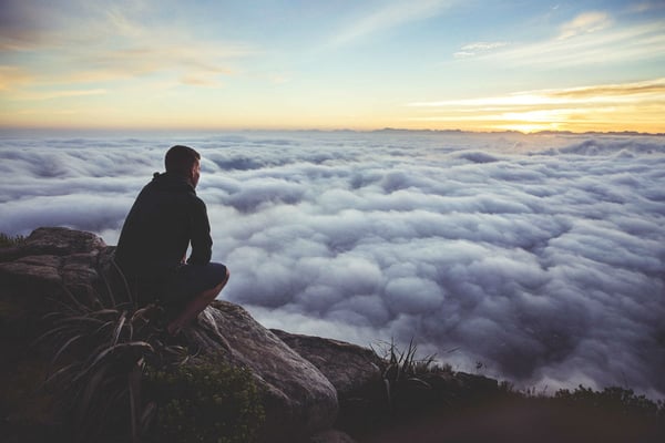 A man looking over clouds signify forward thinking in Manufacturing Industries