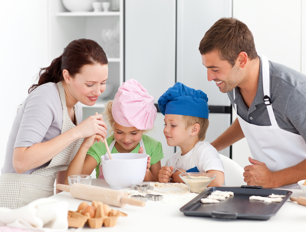 Adorable family baking together in the kitchen to make delicious cookies