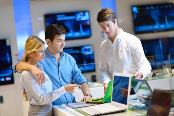 Young couple in consumer electronics store looking at latest laptop, television and photo camera